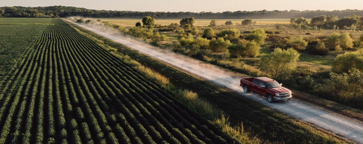 Upward View of GM Truck Driving Down a Farm Road