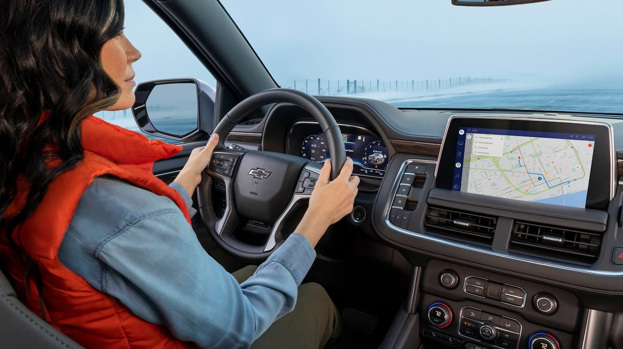A woman driving her GM vehicle through the snow