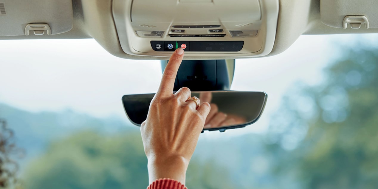 Driver Pressing Emergency Button on Rear View Mirror