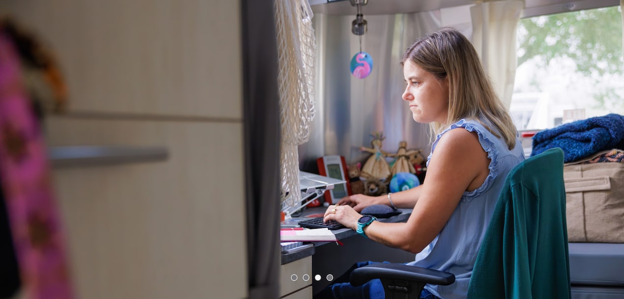 A woman sitting at a desk while typing on a keyboard.