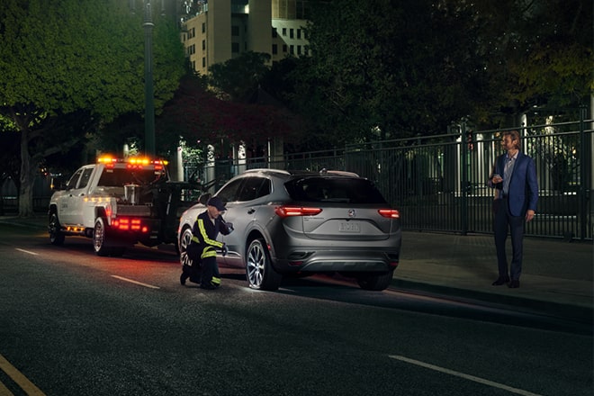 Roadside Assistance Changes a Tire at Nighttime
