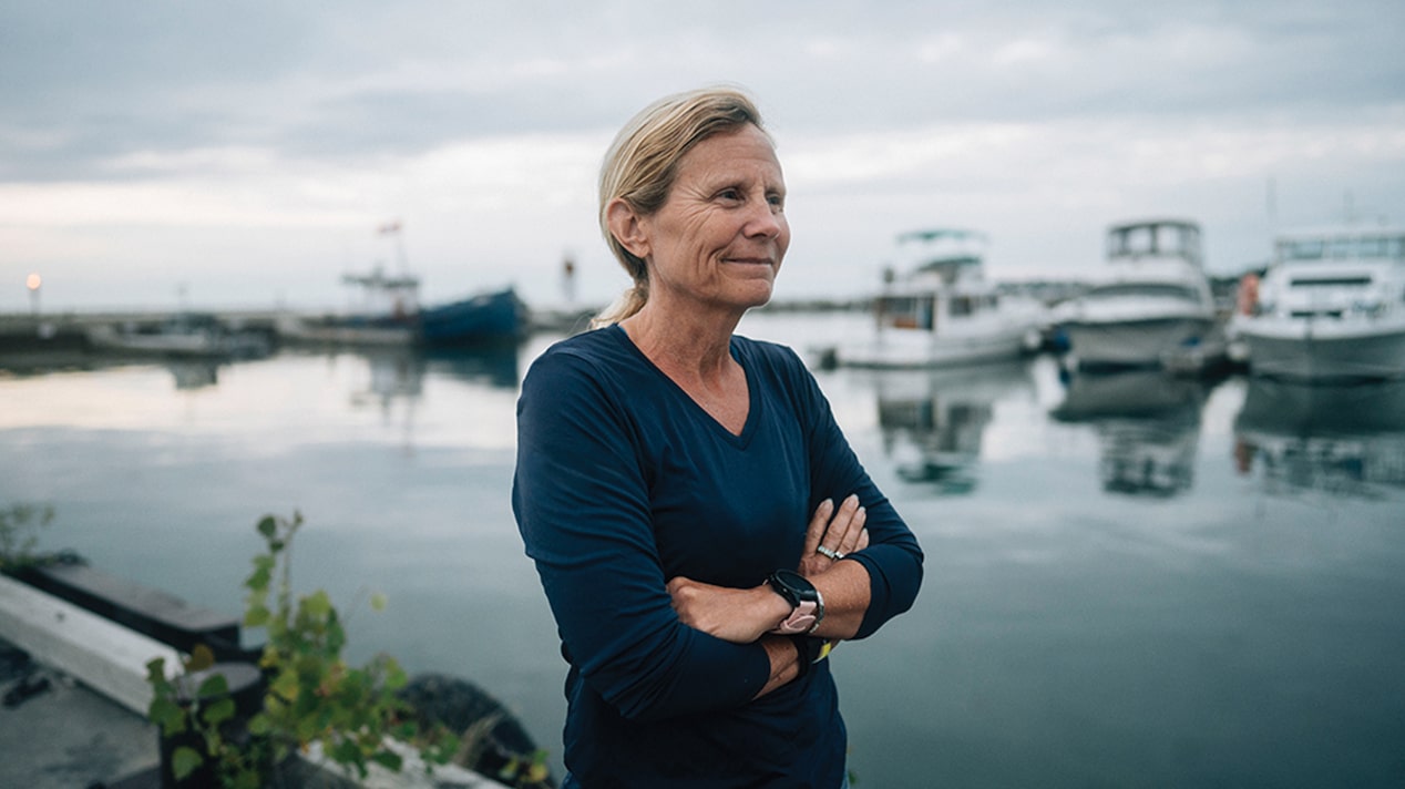 Sondi Stands Near the Water & Boats are Docked in the Background
