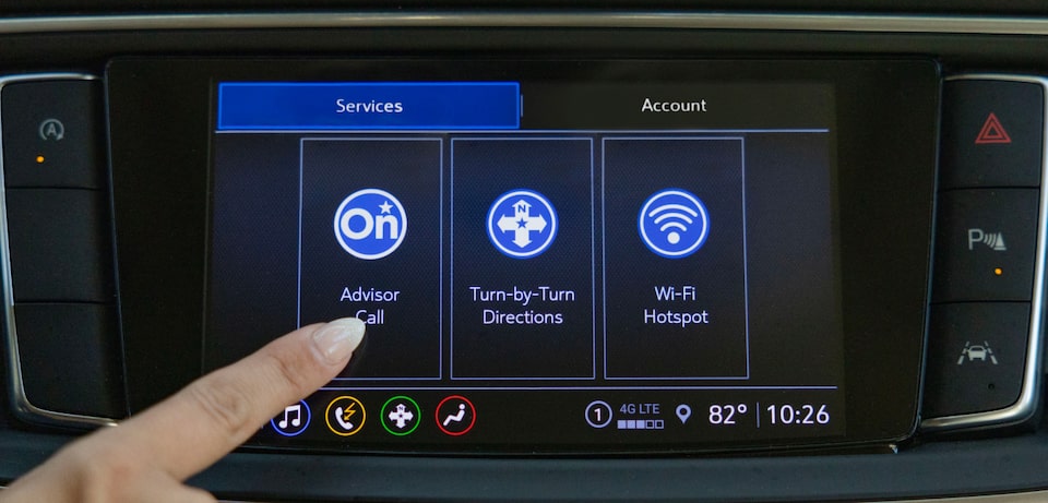 Image of a person pressing the OnStar advisor call button on their vehicle's infotainment system