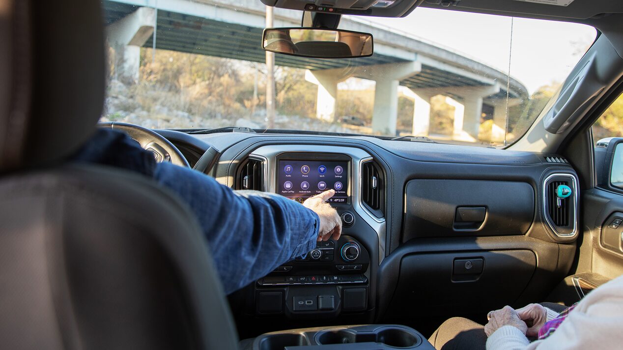 Back Seat POV of Driver Pressing the Infotainment Screen