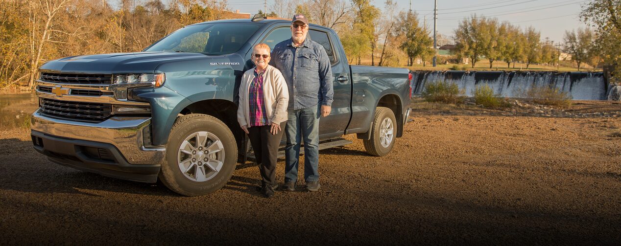 Glen and Roxanne Standing in Front of their Chevy Truck