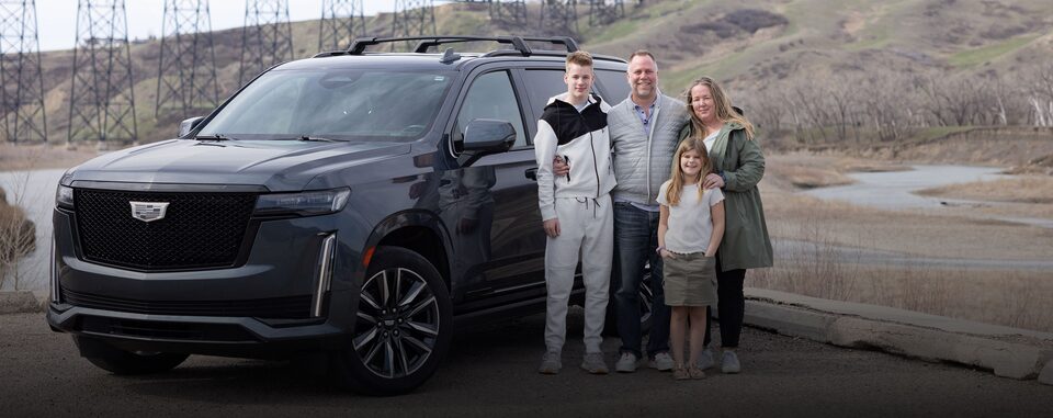 The VanDyk family posing for a picture next to their 2021 Cadillac Escalade