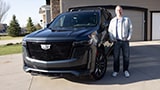 Justin smiling while standing next to his 2021 Cadillac Escalade