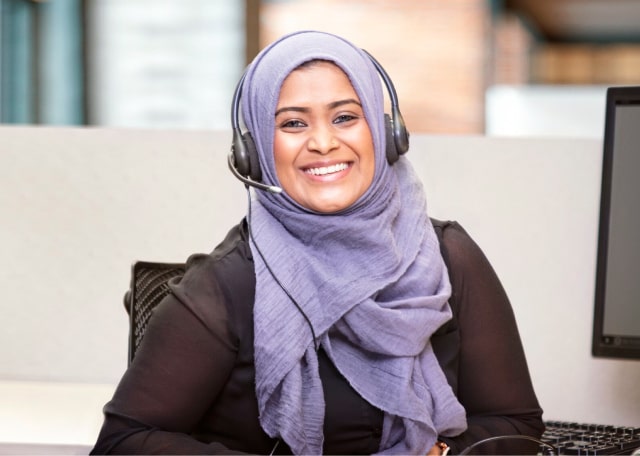 A female OnStar advisor smiling with a headset on