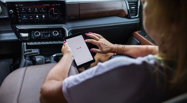 A woman in the front passenger seat using her tablet