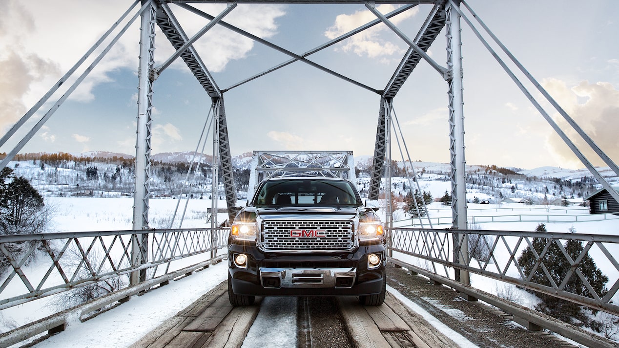 GMC Pickup Truck Crossing a Snowy Bridge