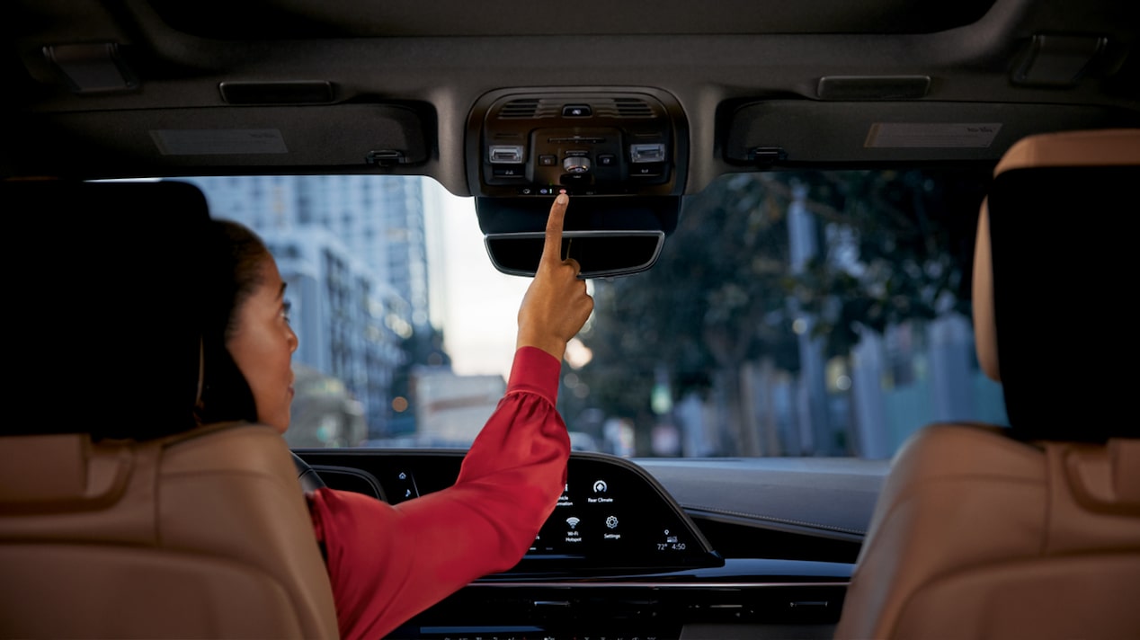 Driver Pressing the OnStar Button in her Vehicle