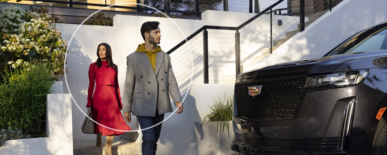 Man & Woman Walking to Their Cadillac Vehicle