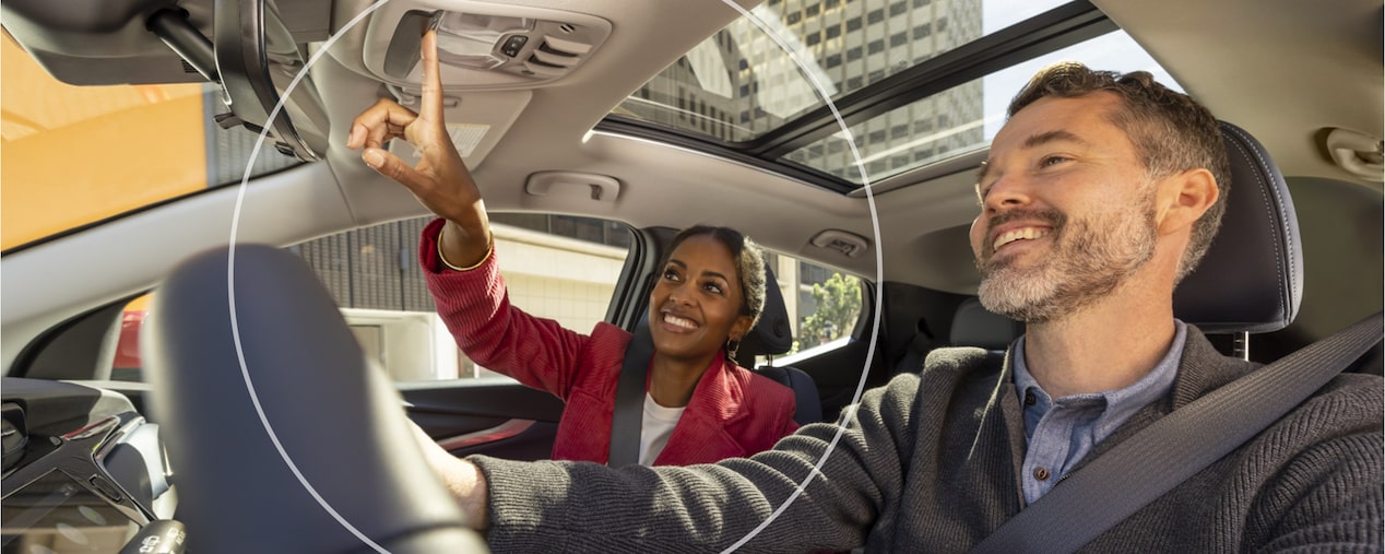 Man Smiling While Driving & Woman Smiling Pushing the OnStar Button