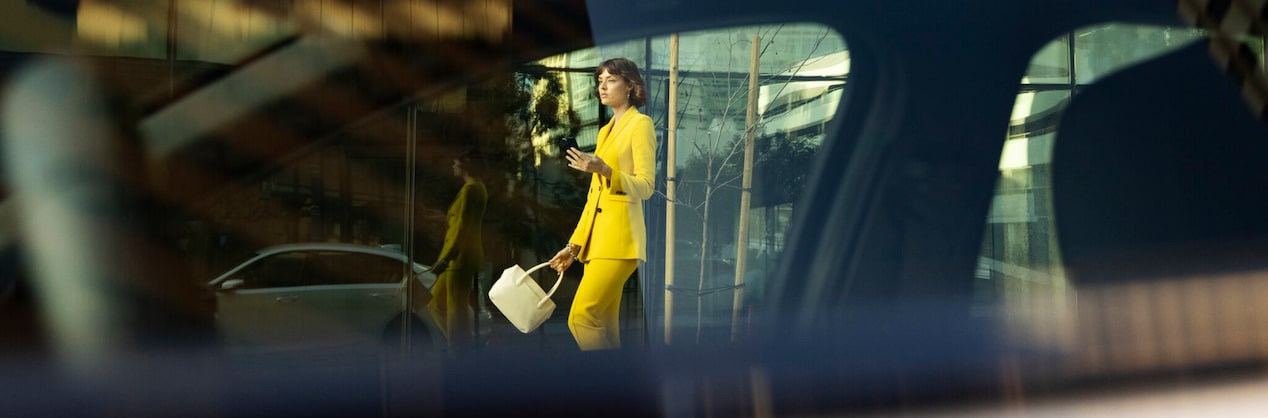 Woman Walking out of a Building Using her Smartphone