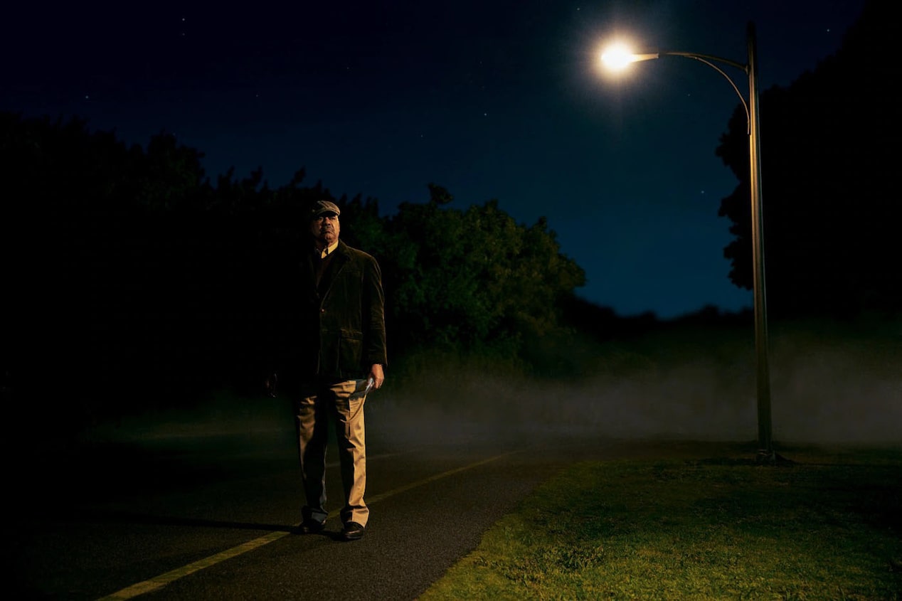 Man Standing by Street Light