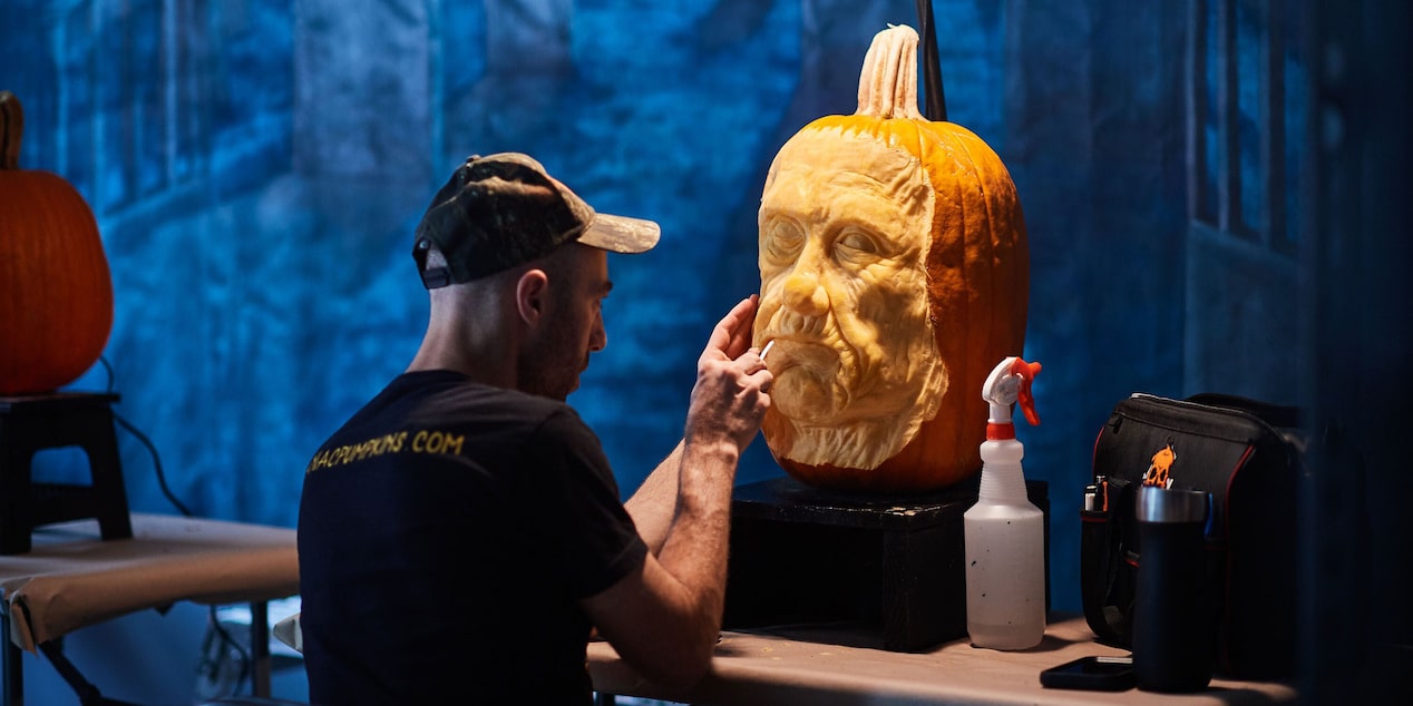 Man Carving Pumpkin in an Eerie Room