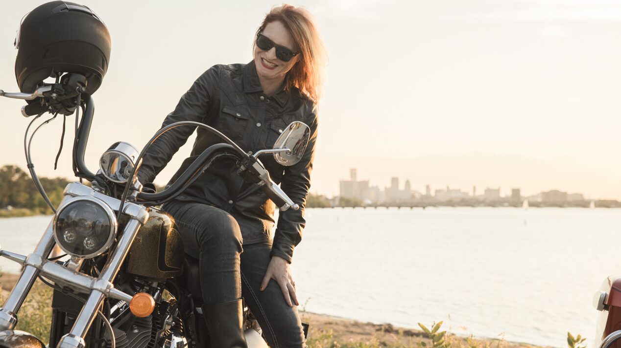 Woman Sitting on Her Motorcycle Parked in Front of the Detroit River