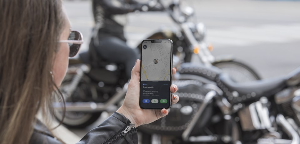 Female Motorcycle Checking the OnStar Guardian App Location Feature
