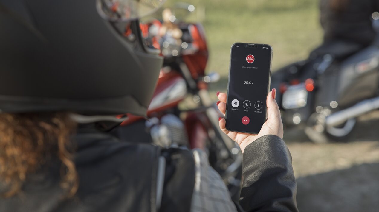 Motorcycle Driver With Helmet on Checking the OnStar Guardian App