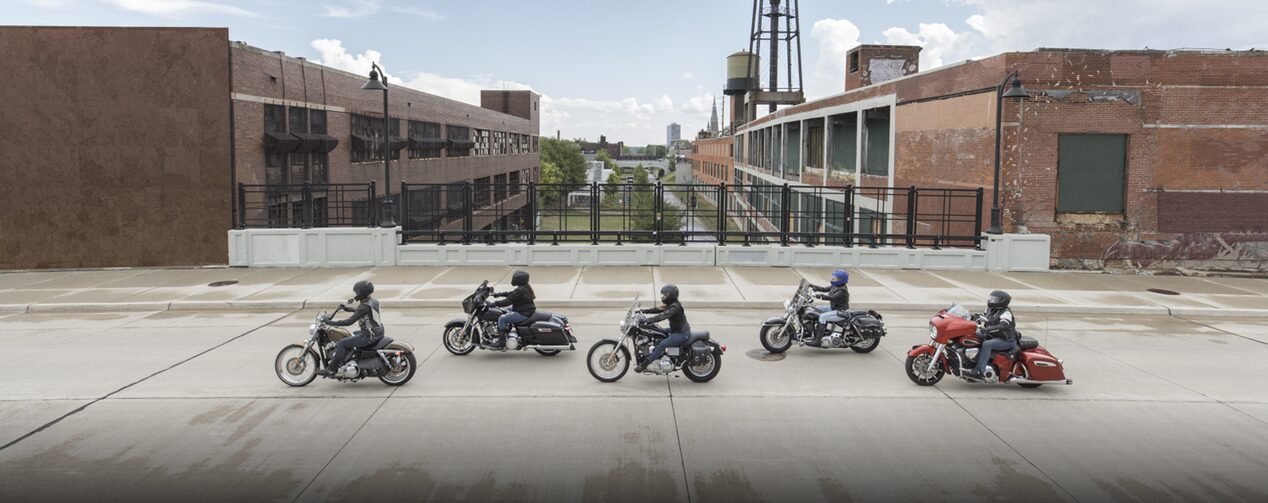 Five Motorcycle Drivers Cross a Bridge in an Industrial Area