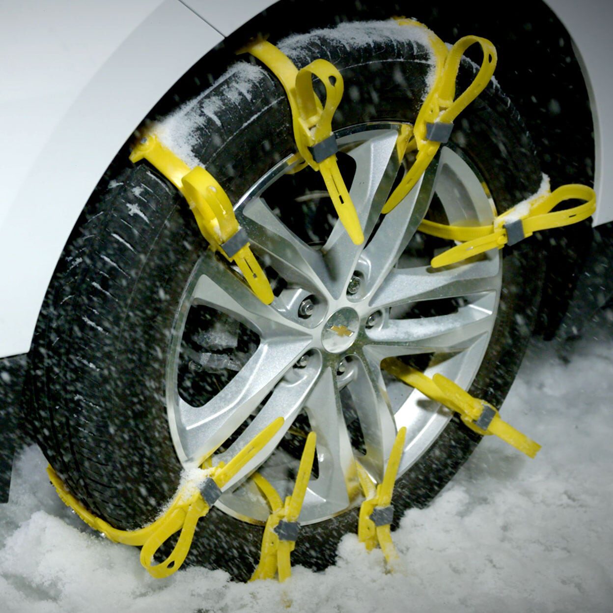 Tire in snow with yellow snow tracks attached
