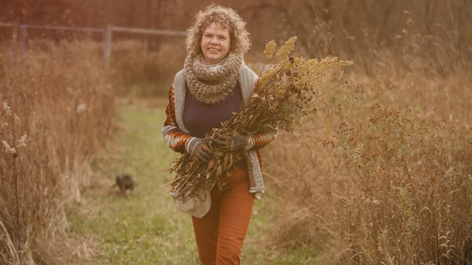 Woman Walking Through Rows of Fall Greenery