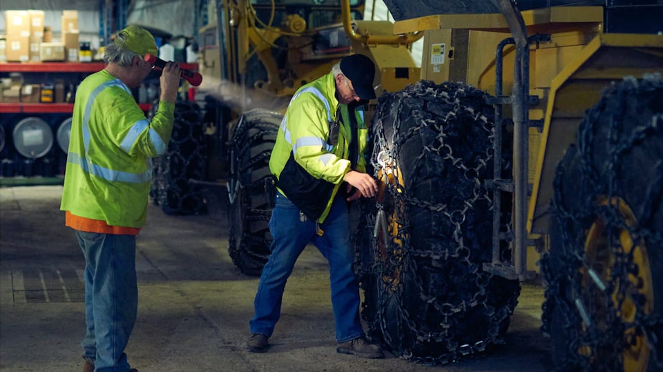 First Responders Inspecting the Wheel of a Tractor