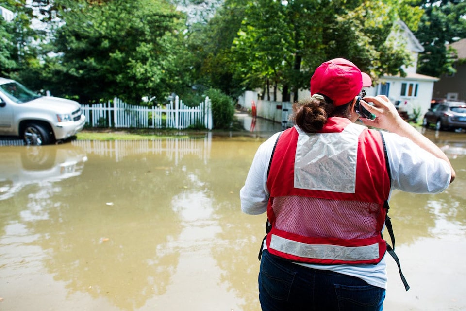 Rescue Worker Stands on the Edge of a Flooded Road