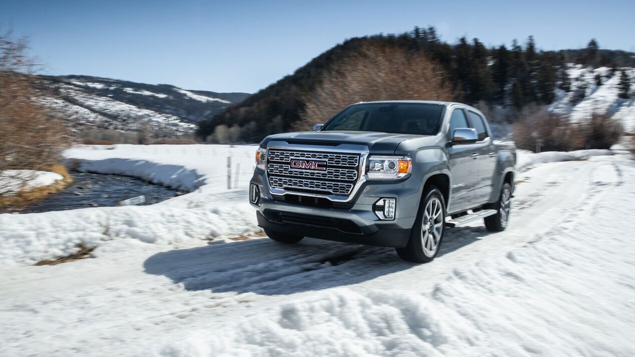 GMC Truck Parked on a Snowy Road in the Mountains