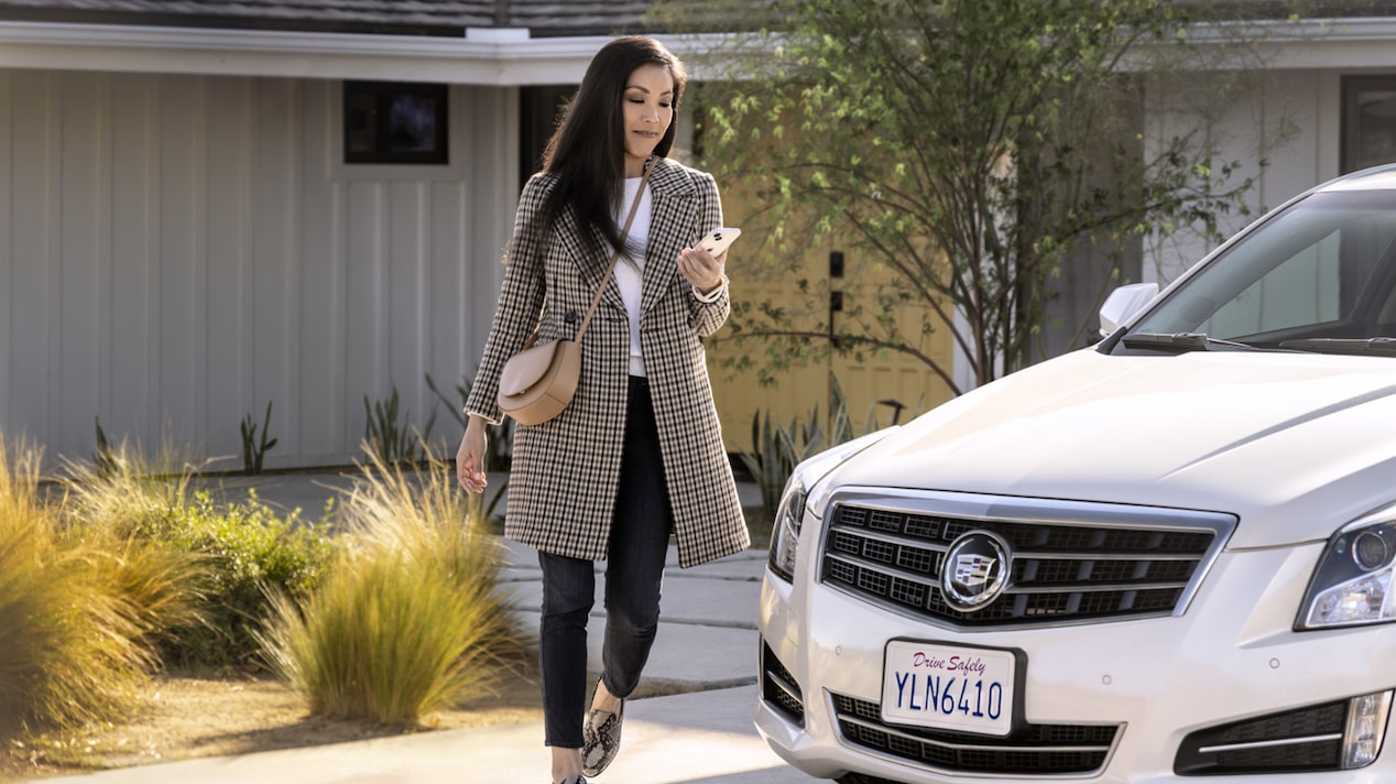 Woman Checking Her Phone and Walking Towards her Cadillac