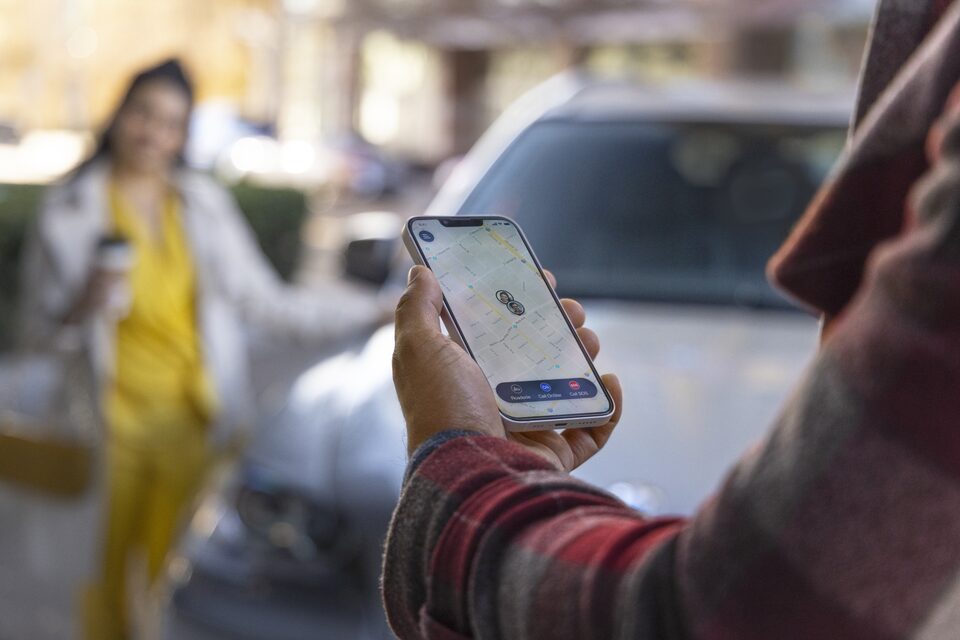 Man Holding Phone with Screen Displaying the OnStar Guardian App