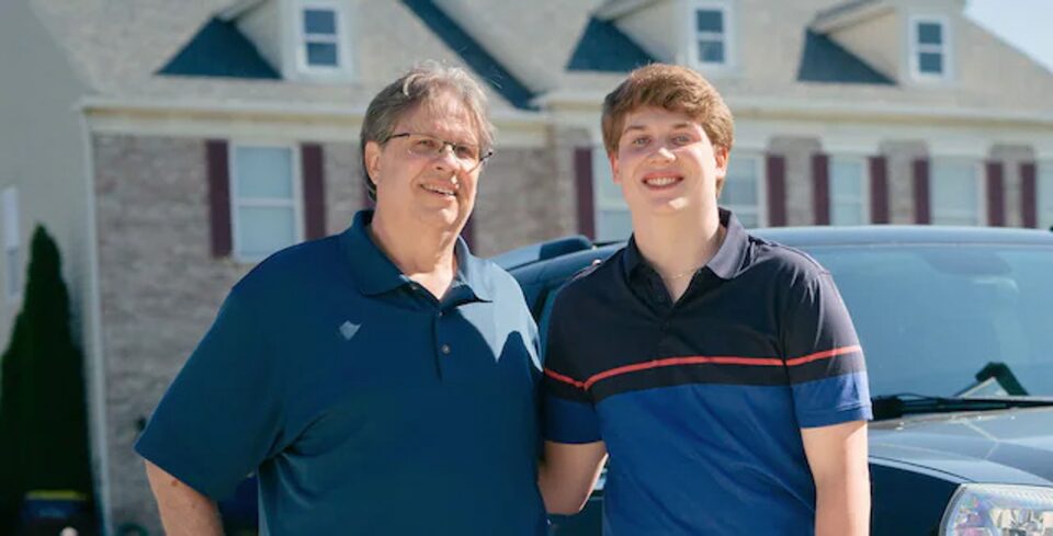 Father and Son Standing in Driveway Smiling