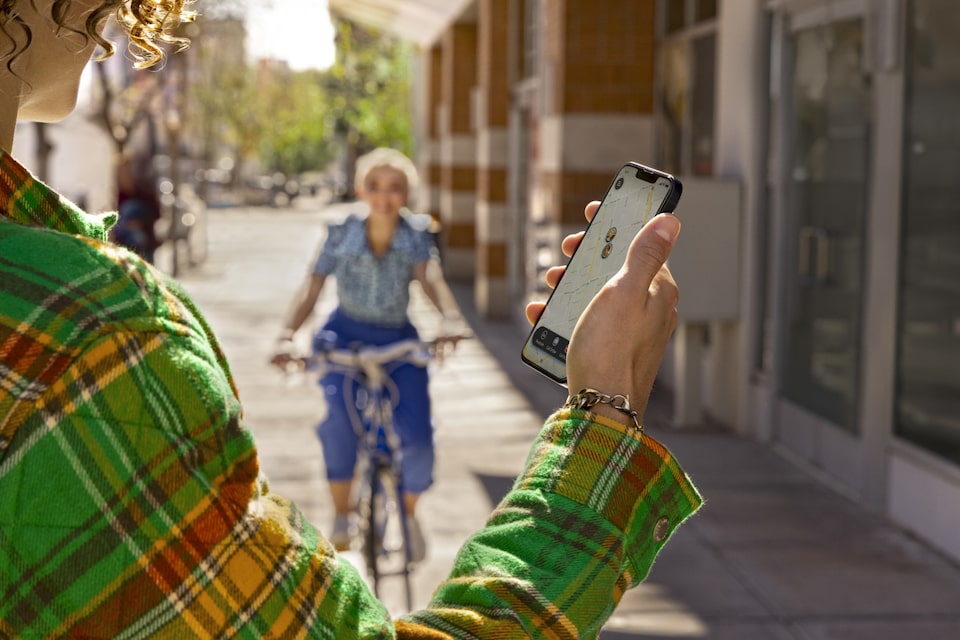 Women Riding Bike Toward Person Using Smartphone